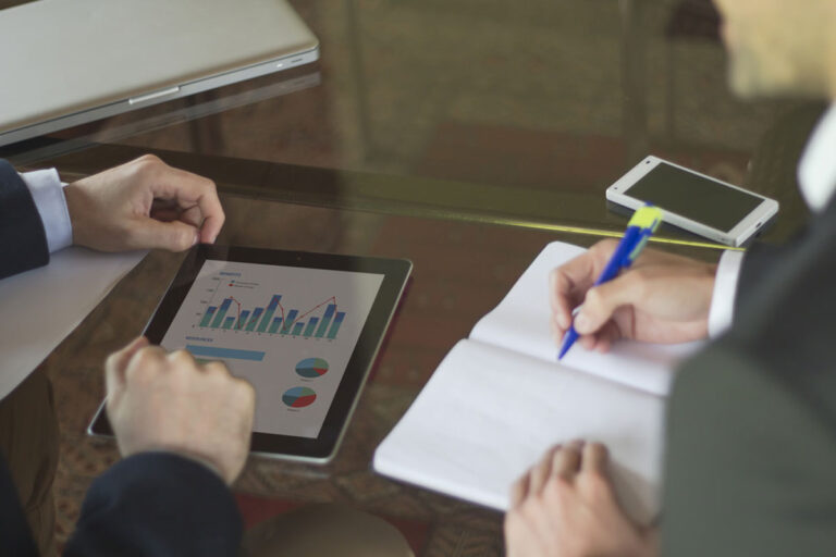 Riunione del team di marketing con un tablet e un blocco appunti.