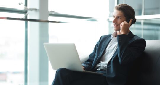 Hotel Manager al telefono che guarda un computer 