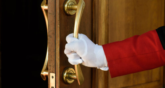 Concierge apre la porta dell'hotel al cliente prima del check-in