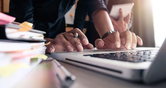 Mani dell'addetto marketing che digitano su un pc