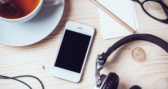 Cellulare con cuffie e the