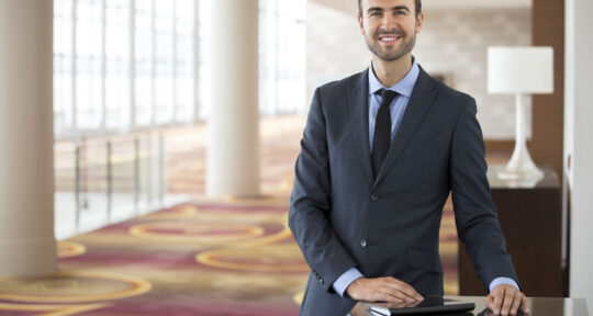 Hotel manager sorride con un tablet