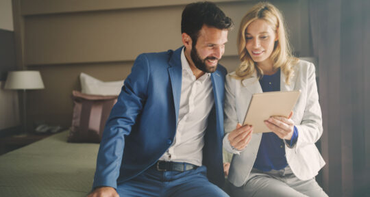 Ospiti felici in camera d'hotel guardano un tablet