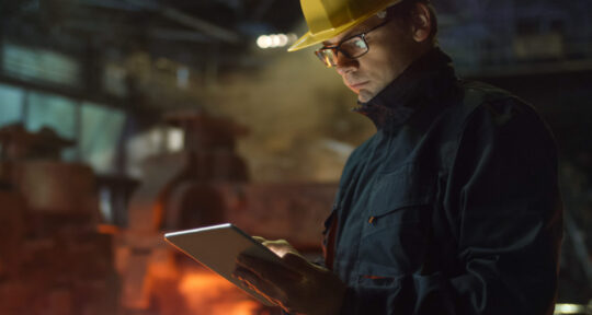 Operatore controlla l'avanzamento produzione con il software MES