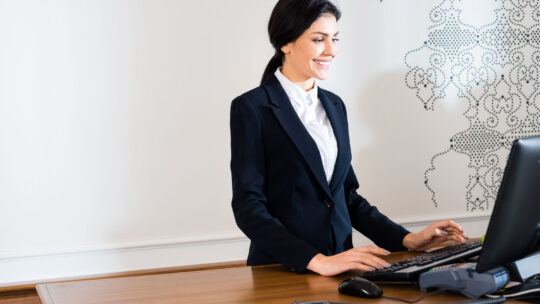 Donna sorridente organizza la gestione turni dello staff in hotel