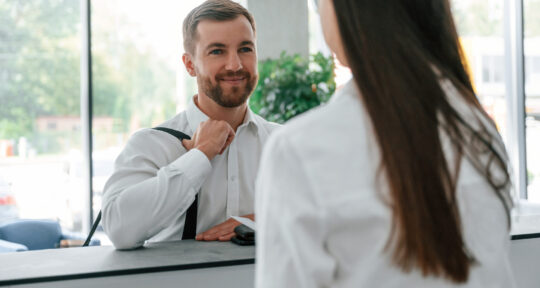 Receptionist dell'hotel mette in pratica una strategia di Upselling con il cliente